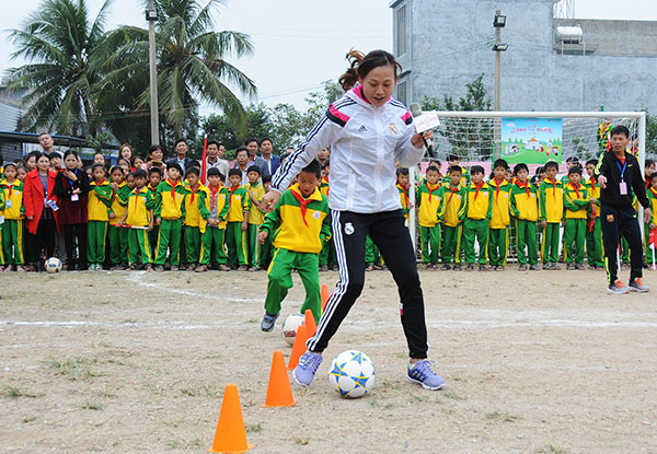 韋海英為孩子們示范足球基本功。