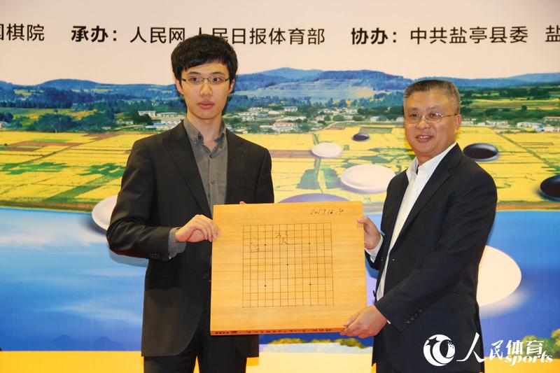 连笑向盐亭县委书记袁明赠送签名棋盘