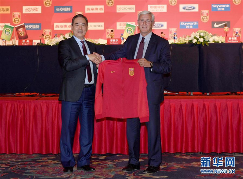 2016年10月28日，時任中國足協主席蔡振華（左）在媒體見面會上向國足新主帥裡皮贈送國足球衣。 新華社記者郭勇攝