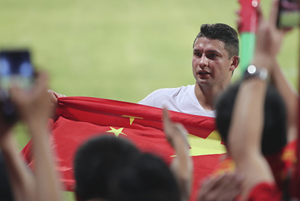 世預賽40強賽國足獲勝 艾克森身披國旗致意球迷中國隊在世預賽40強賽中5-0戰勝馬爾代夫。賽后，艾克森和另一位歸化球員李可來到場邊感謝中國球迷，面對球迷們贈與的國旗，艾克森毫不猶豫披在身上。
