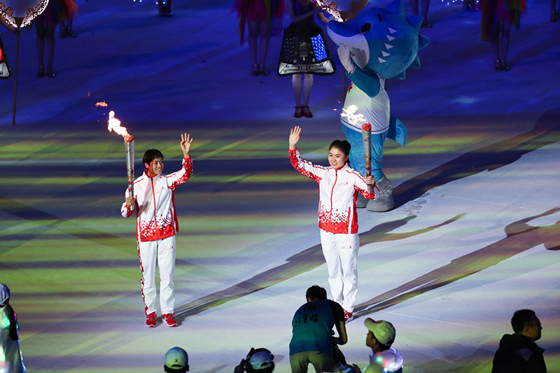 第三棒火炬手王堂林（左）與第四棒火炬手焦劉洋傳遞火炬